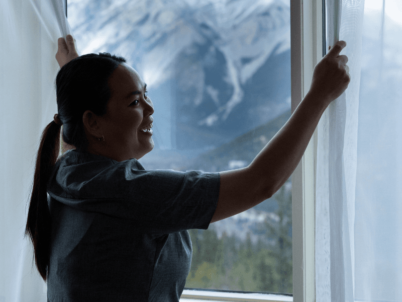 Housekeeping team member opening curtains Housekeeping team member opening curtains